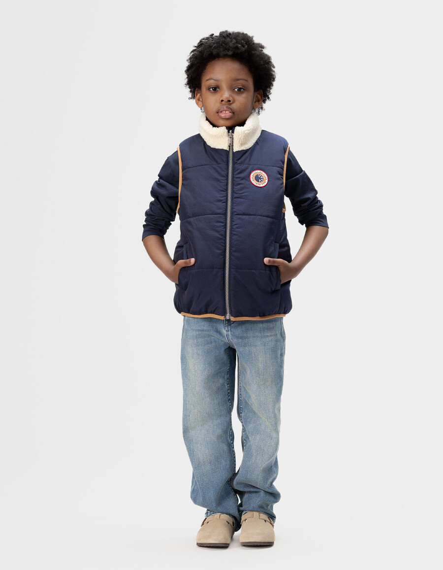 chaqueta acolchada sin mangas reversible en color crudo y azul marino para niño