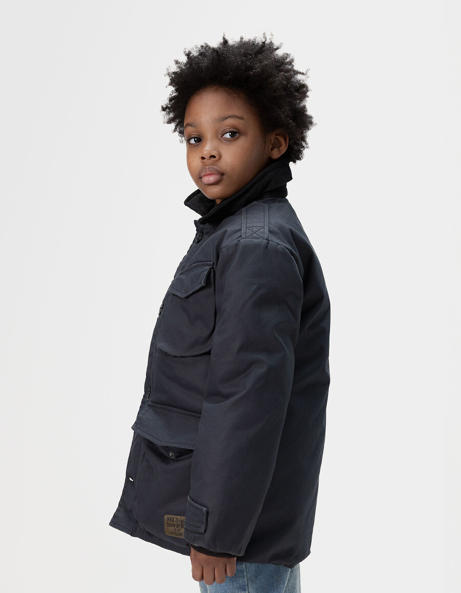 parka negra multibolsillos con cuello de terciopelo para niño