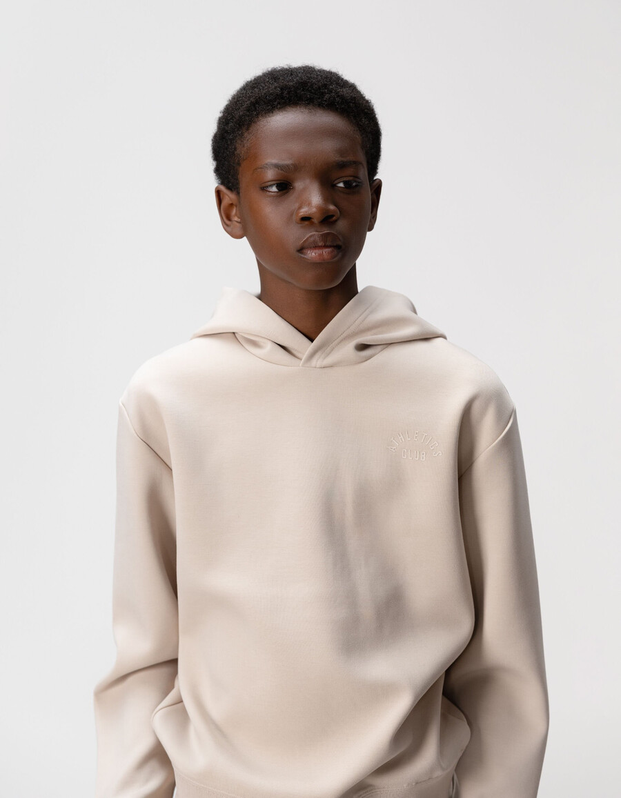 sudadera beige para niño con eslogan en relieve en la espalda