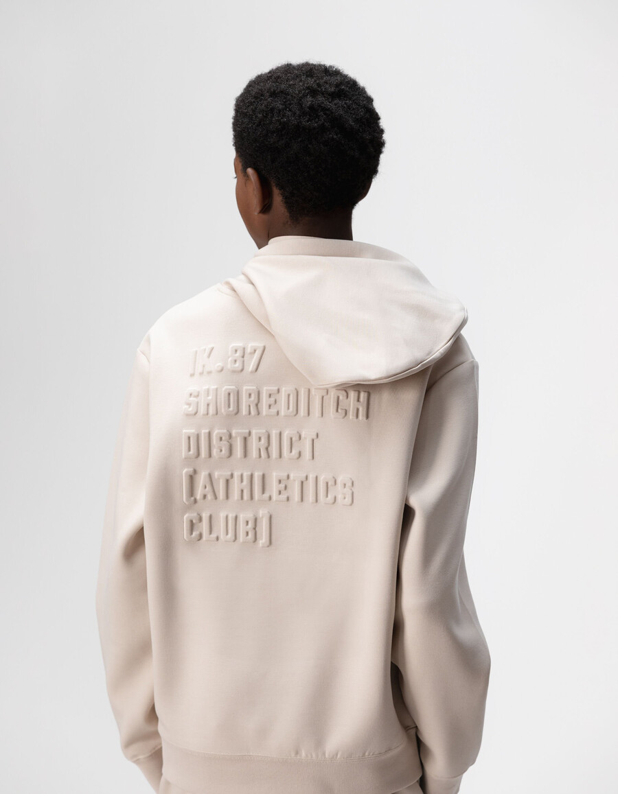 sudadera beige para niño con eslogan en relieve en la espalda