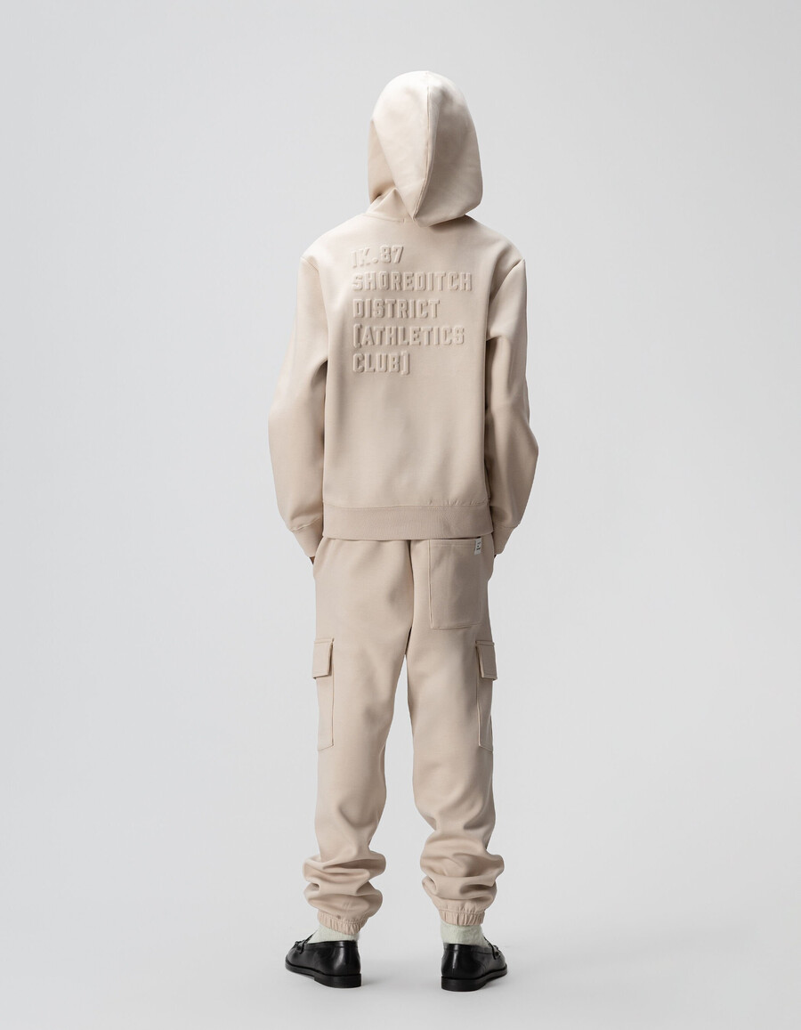 sudadera beige para niño con eslogan en relieve en la espalda