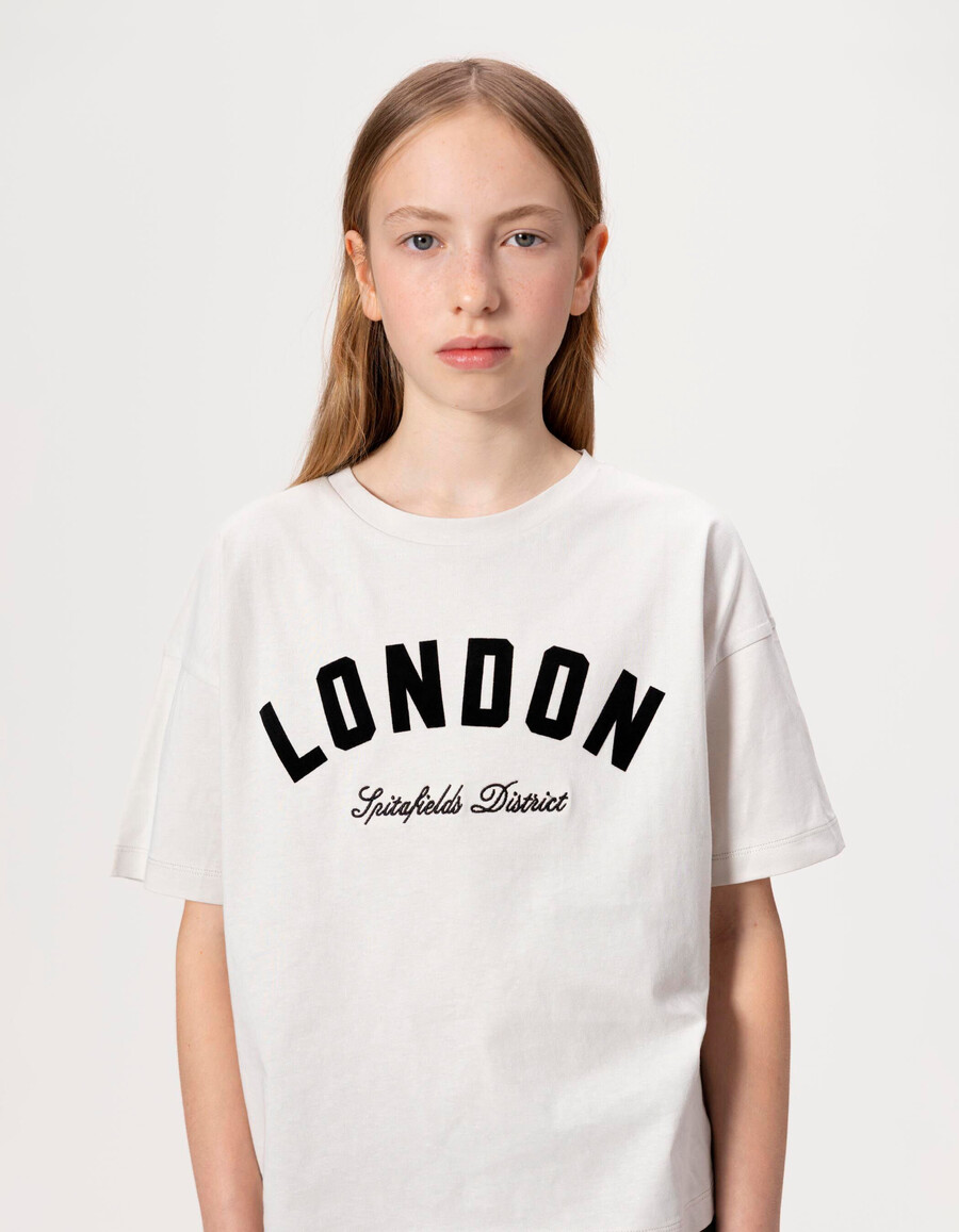 camiseta de algodón orgánico beige para niña con eslóganes negros